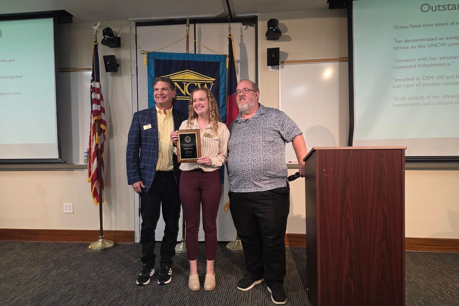 Award nominee posing with plaque.