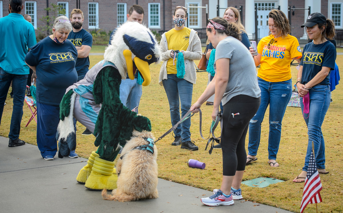 Our mascot Sammy Seahawk pets a service dog