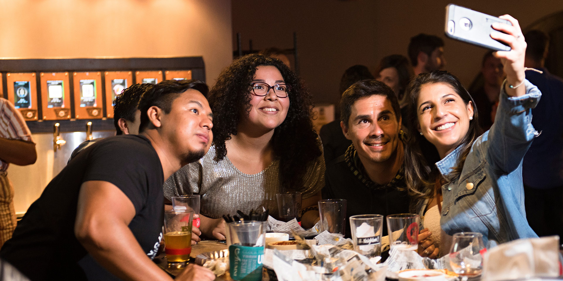 4 students pose for a selfie during dinner