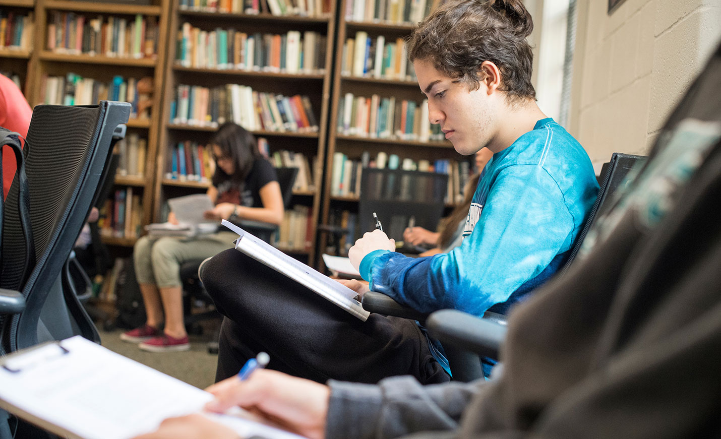 Student taking notes in a library