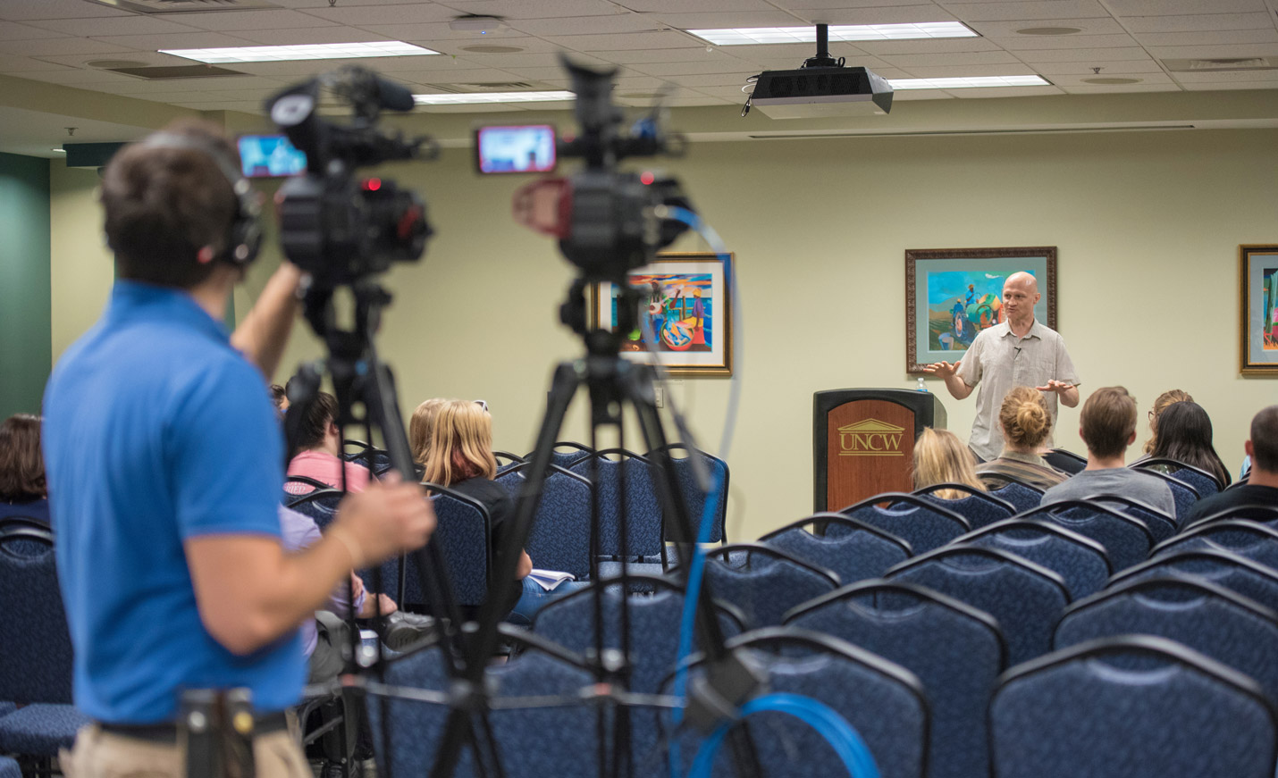student filming a speaker 