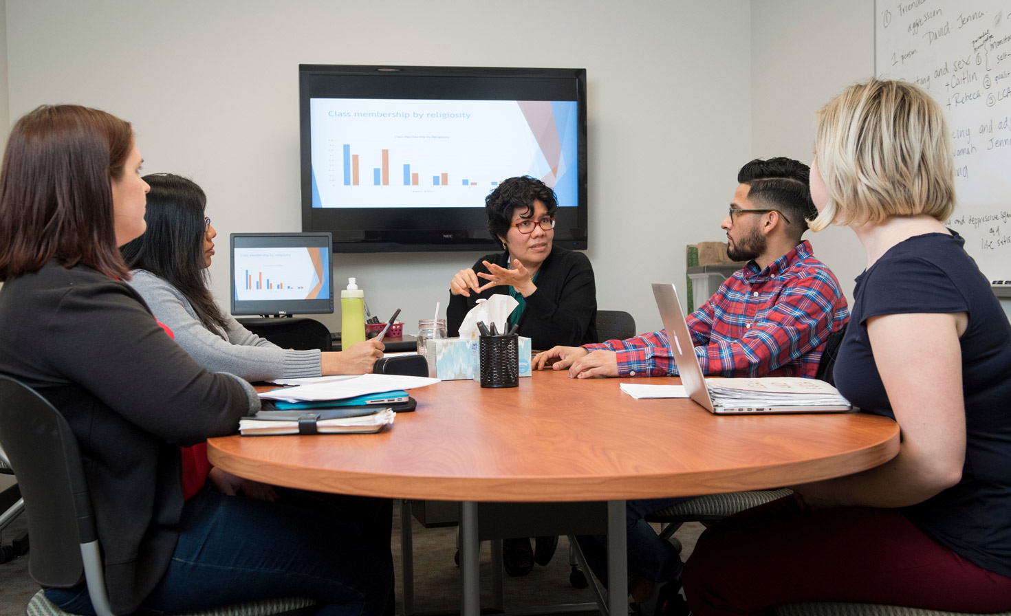 Dr. Maria Graciela Espinosa speaks with students at a table