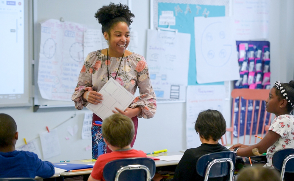 Watson student standing in front of a classroom of elementary students teaching