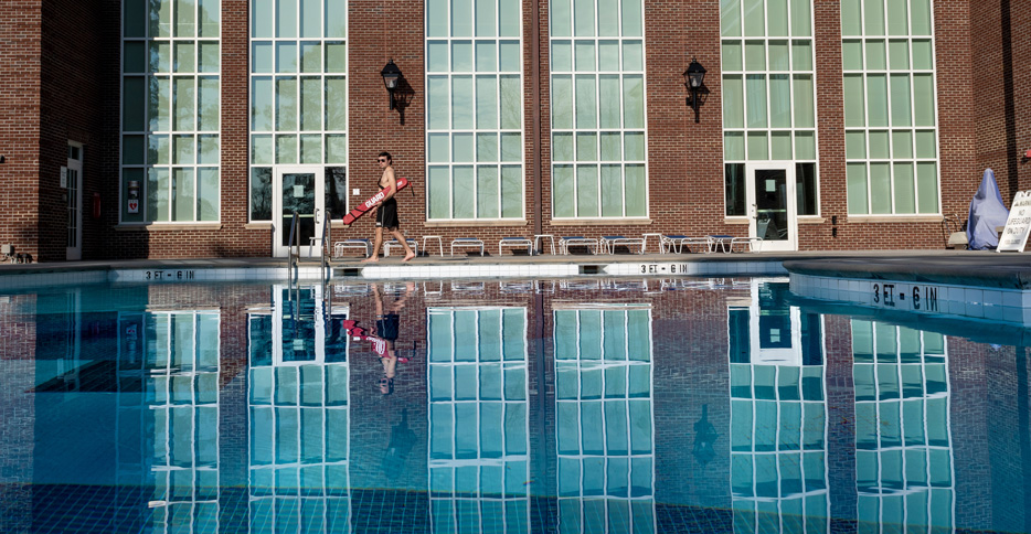lifeguard walks along the outside of the leisure pool