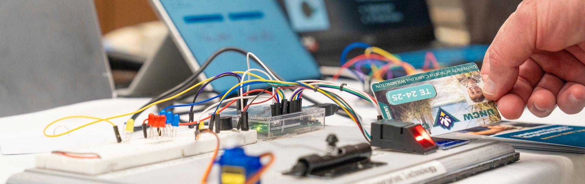Person swiping one card on a machine at a computing showcase
