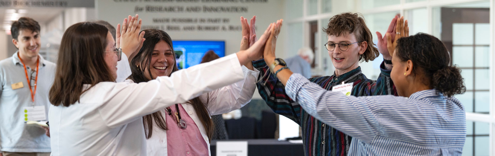 Students high-fiving each other in a circle