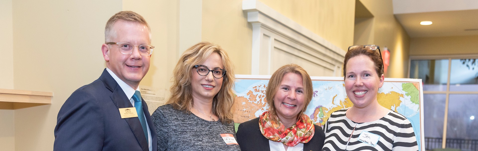 four people smiling at international faculty staff