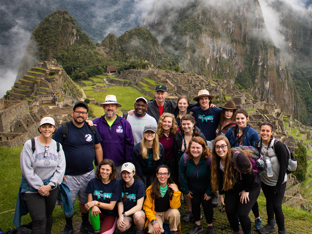 A group of students poses at the famous lookout of Machu Picchu