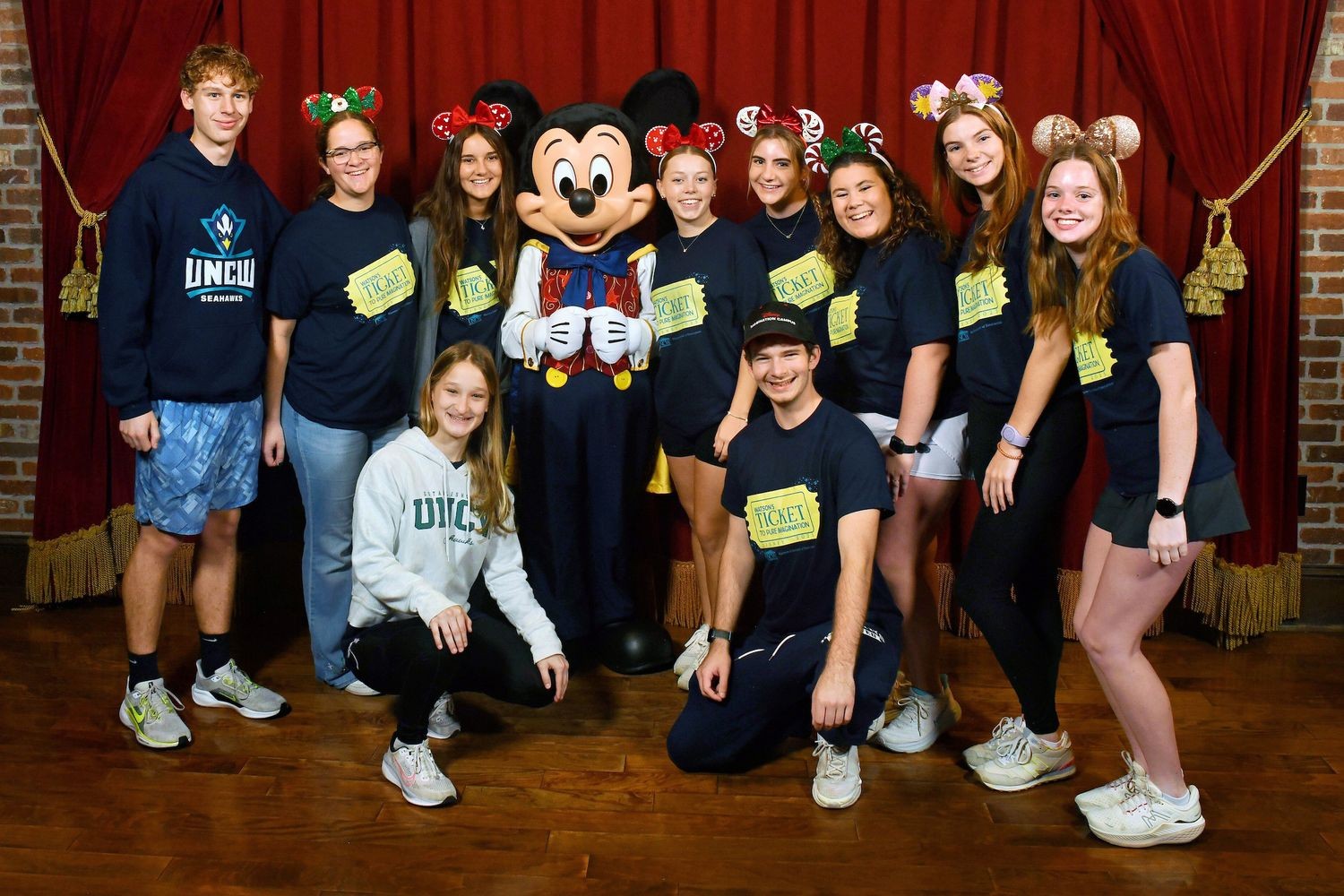 Students posing with Mickey Mouse