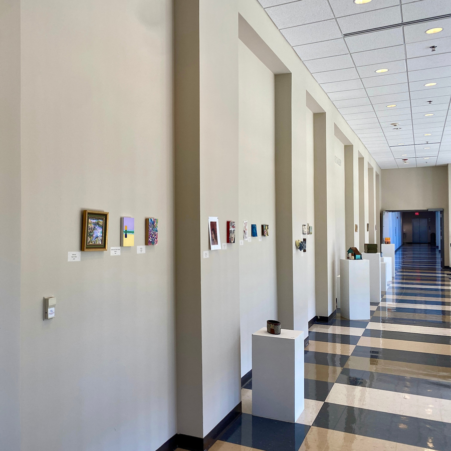 Mezzanine Gallery hallway leading to a door with art on the walls