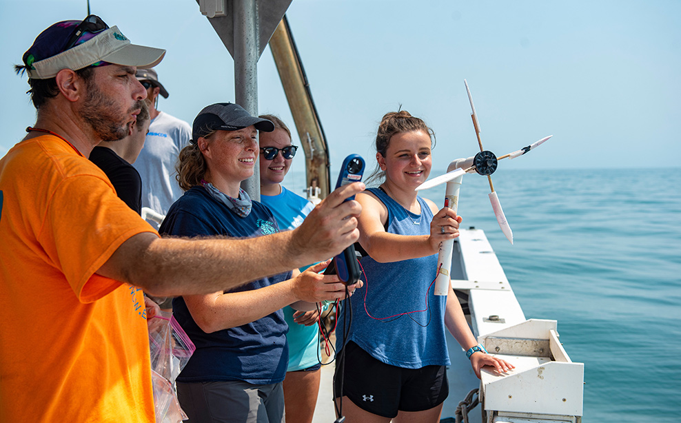 People on boat using a wind turbine.
